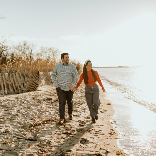 Couple hand in hand walking down the beach